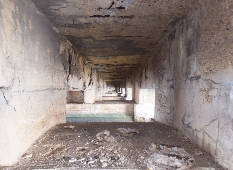 View looking through several concrete supports under pier