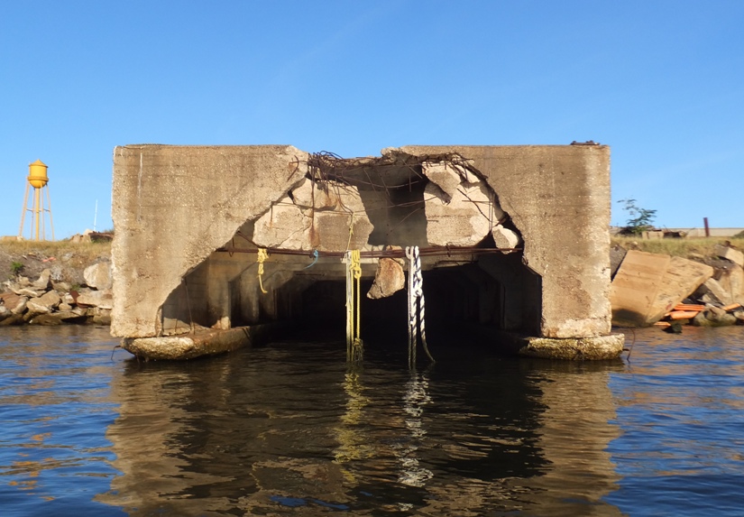 A short concrete pier with a piece of concrete hanging by rebar