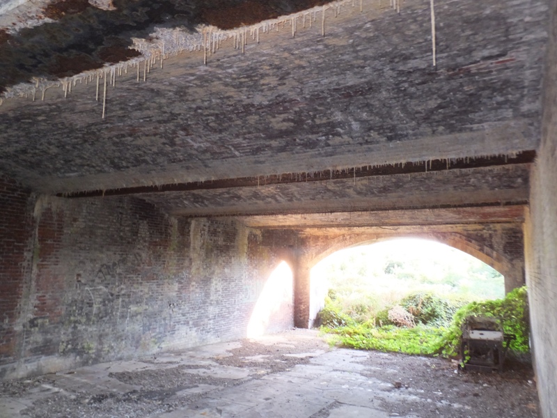 Lots of skinny stalactites handing from brick ceiling