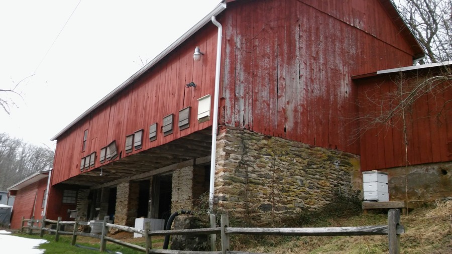 Red barn with masonry botton floor and bee apiary