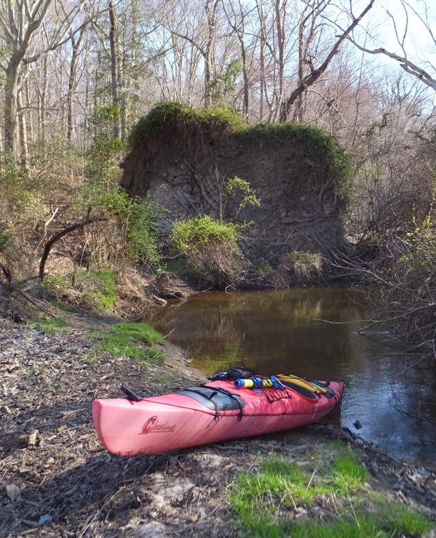 My kayak ashore with tree root base behind