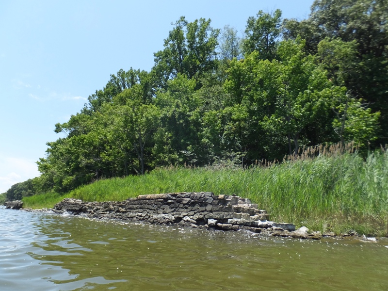 Crumbling stones laid into a wall by the water