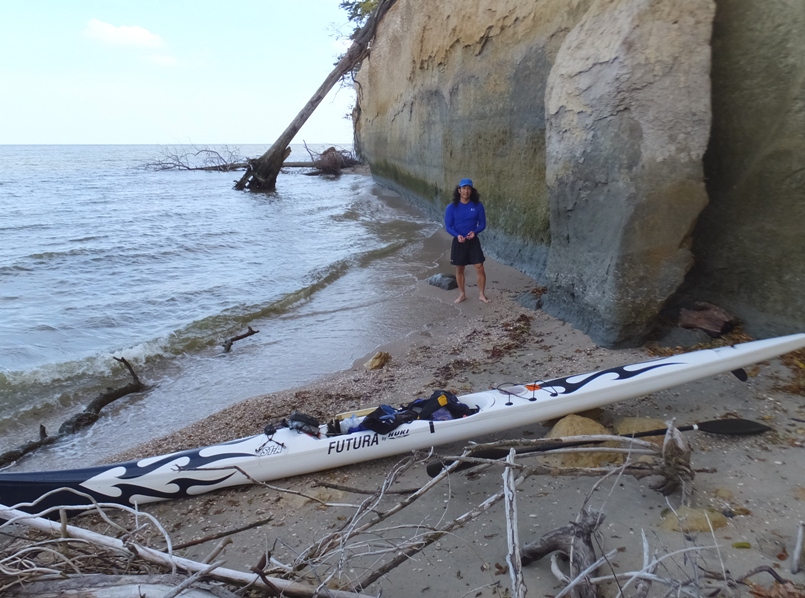 Me standing by surfski on small beach next to cliff
