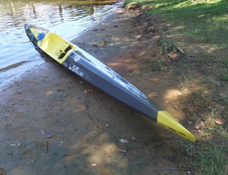 Black and yellow Stellar surf ski on the shore