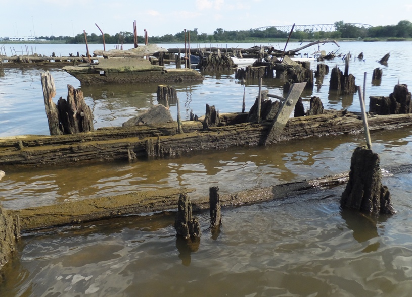 Rotting wood with metal and a bridge in the distance