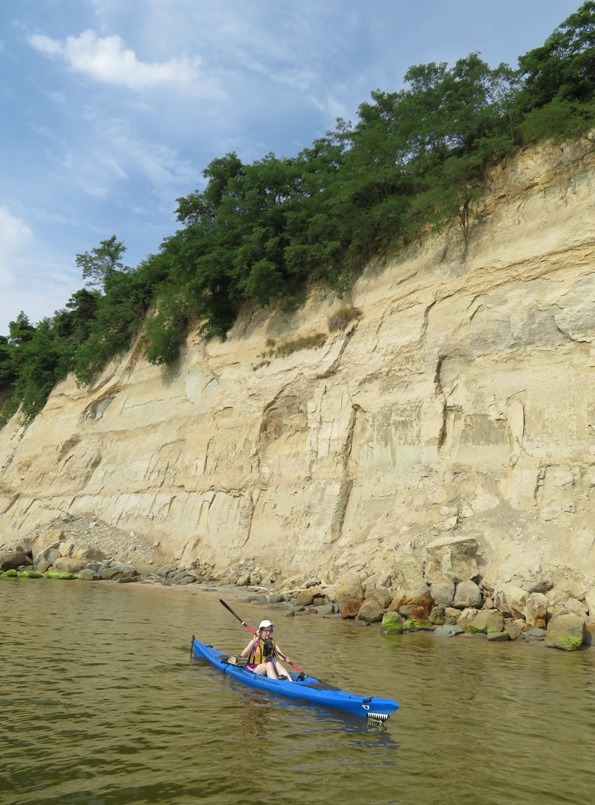 Norma kayaking with cliff behind
