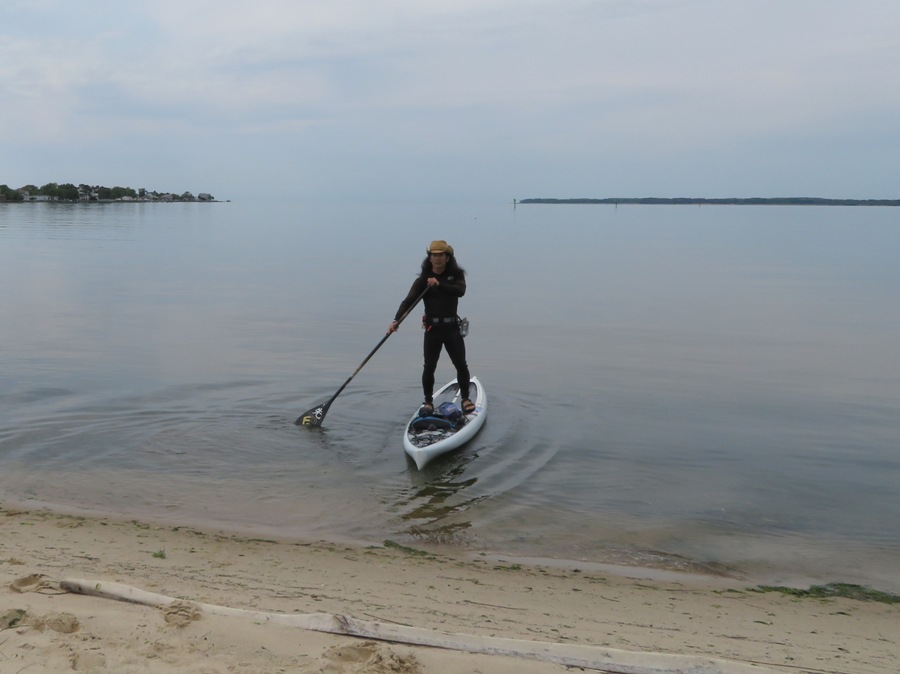 Me on SUP with flat water to the horizon and Eastern Neck Island in the distance