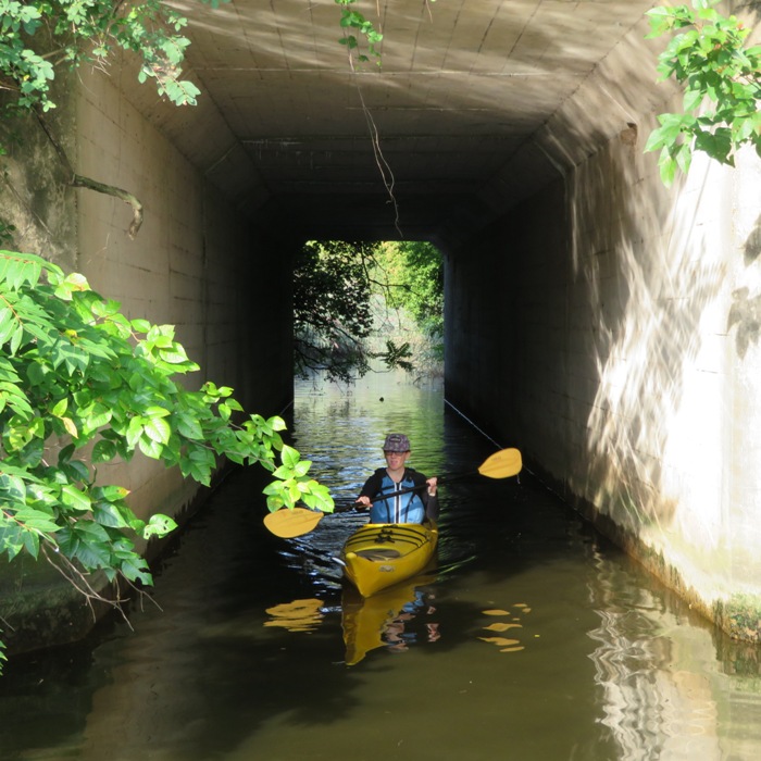 Sara in her kayak at entrance of tunnel