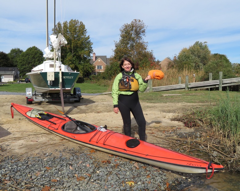 Lisa standing by her kayak holding a sponge
