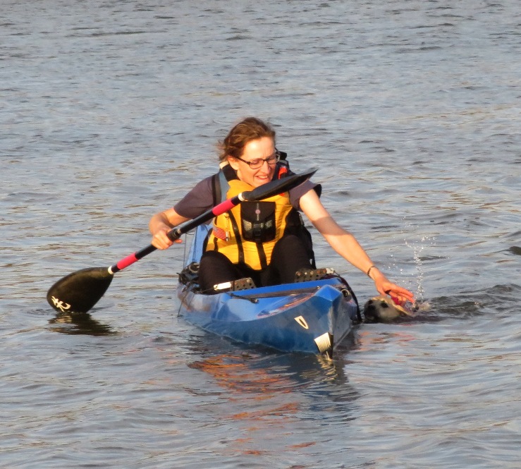 Norma reaching to pull Daphne out of the water