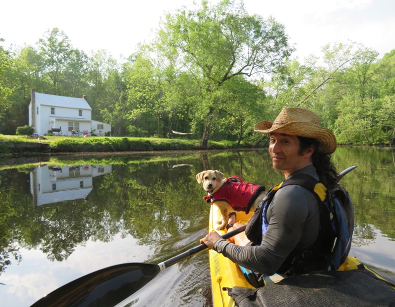 Daphne and me on kayak with a waterfront house behind us