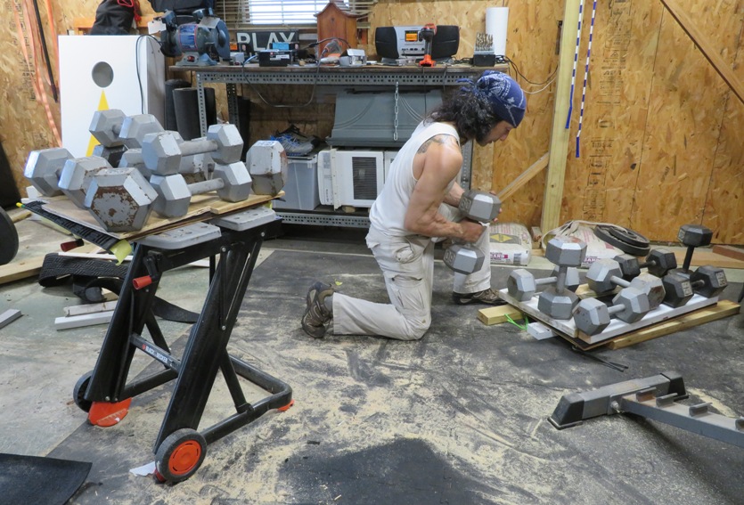 Me putting dumbbells on kayak platforms to glue things in place