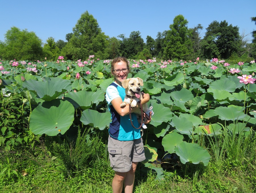 Norma holding Daphne with pink lotus flowers behind