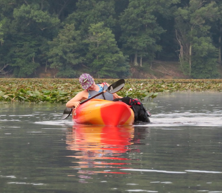 Sara pulling Cassi out of the water and into her kayak