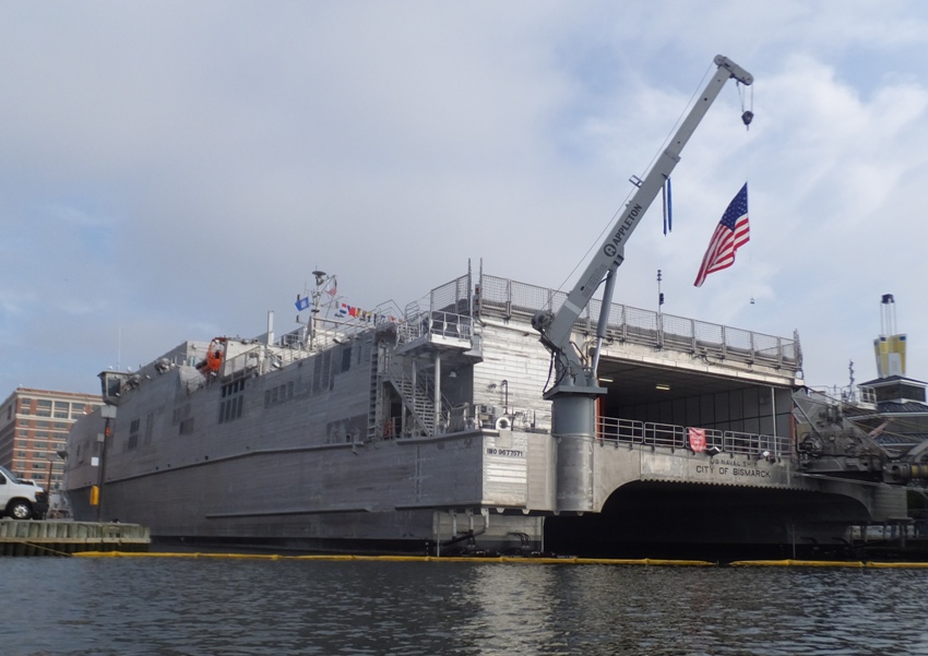 Rear port view of ship with flag hanging from crane