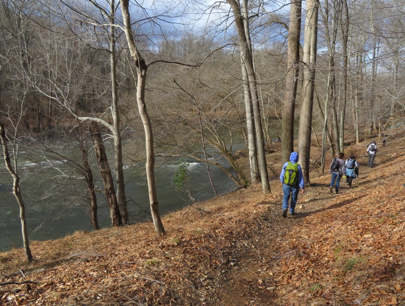 Hikers walking with the river in the background