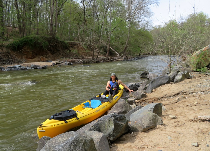 Me in kayak on shore with riffles behind