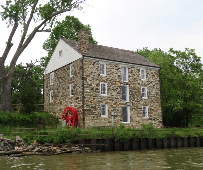 Stone grist mill with red water wheel