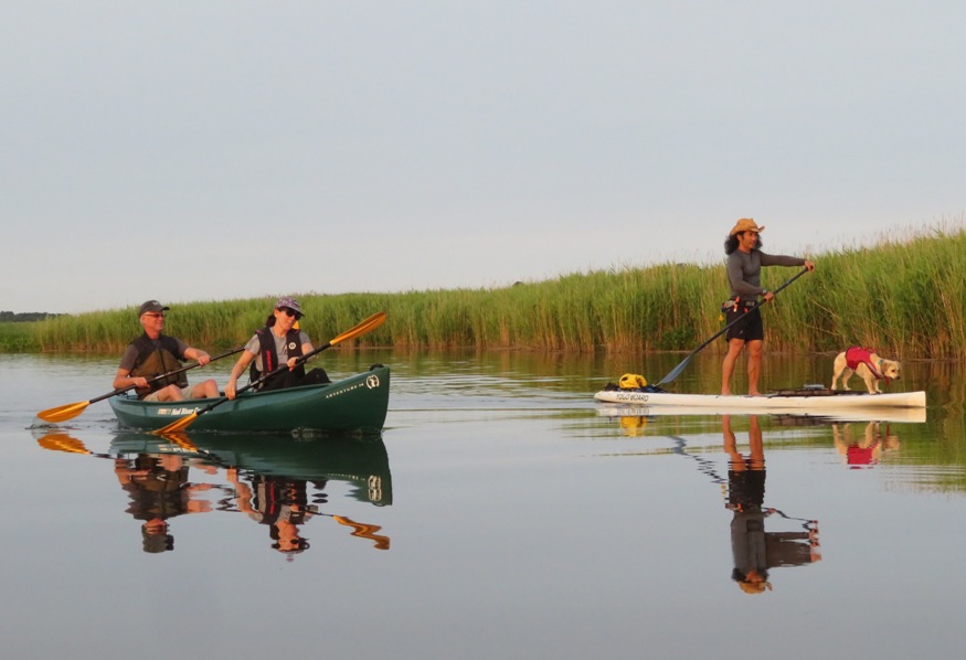Sara and Mike in canoe with Daphne and I on SUP in low light
