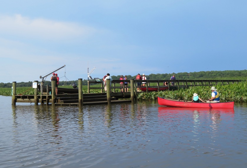 End of river pier with red canoe in the water