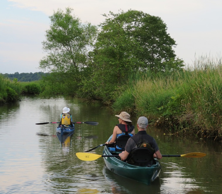 Norma, Sara, and Mike on the water as it starts to get dark