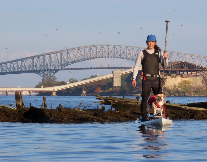 Daphne and me on SUP with wreck and bridge behind
