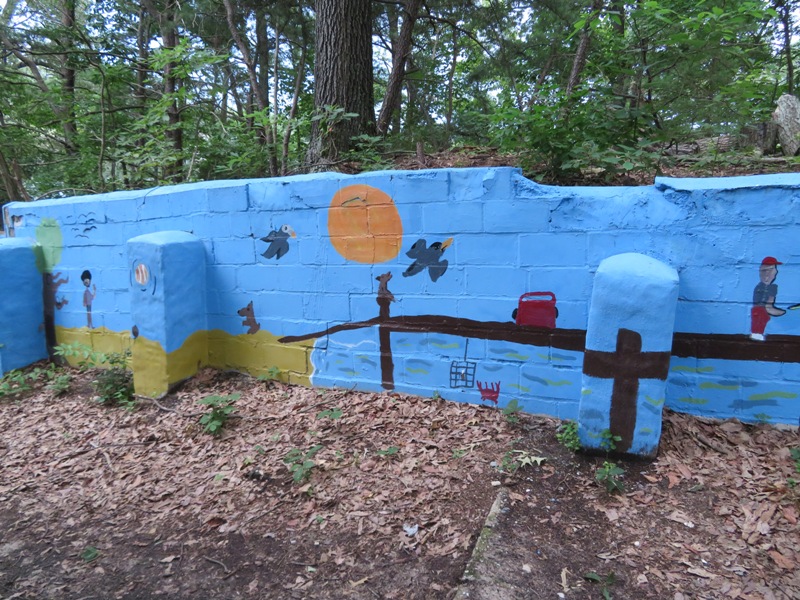 Low cinder block wall painted blue and decorated