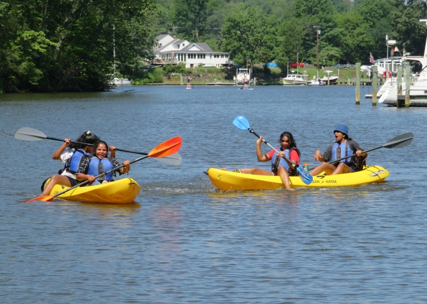 Malar and her daughters engaged in a splash fight from the kayaks