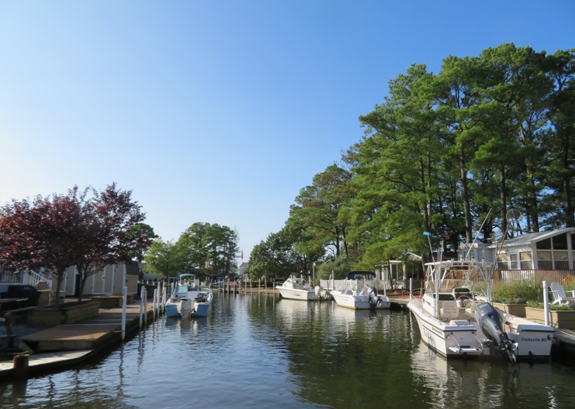 Powerboats parked along the waterway near the mobile homes