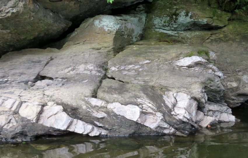 Rocks by the water with streaks of white