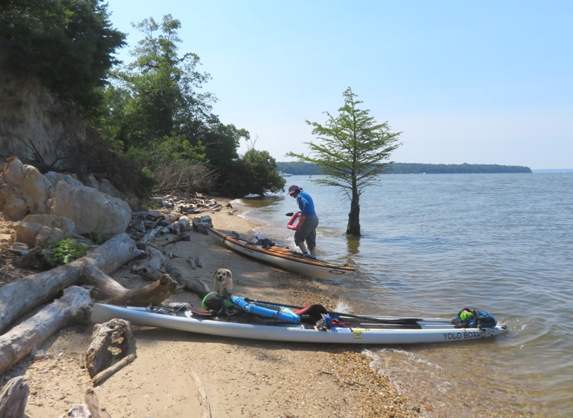 Marla on the beach with her kayak and Daphne with SUP in the foreground