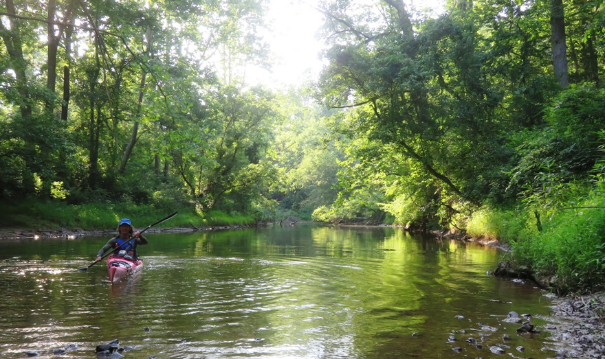 Me on kayak in shaded, wooded area