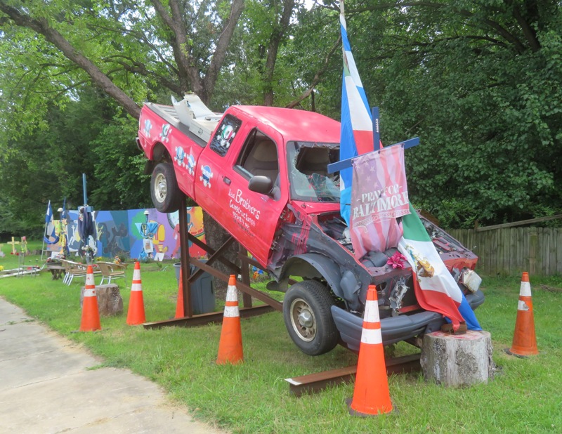 Eleated red truck wreck with 'Pray for Baltimore' flag