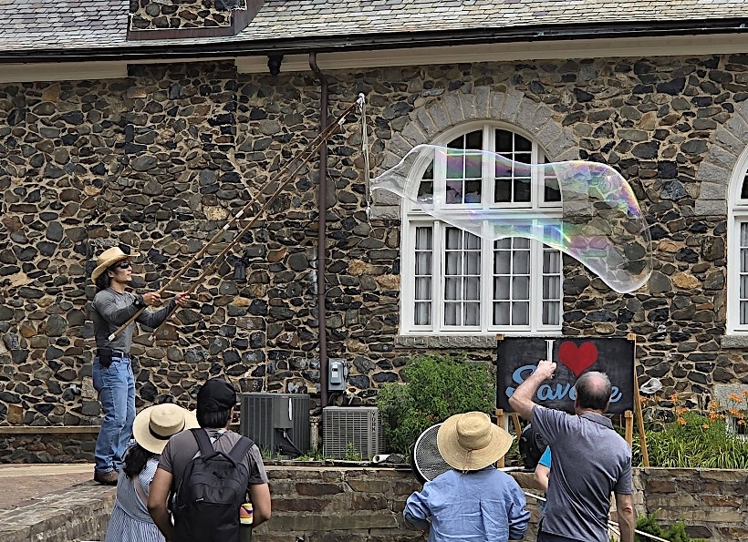 Me standing on the stone wall making bubbles with Carroll Baldwin Hall in the background