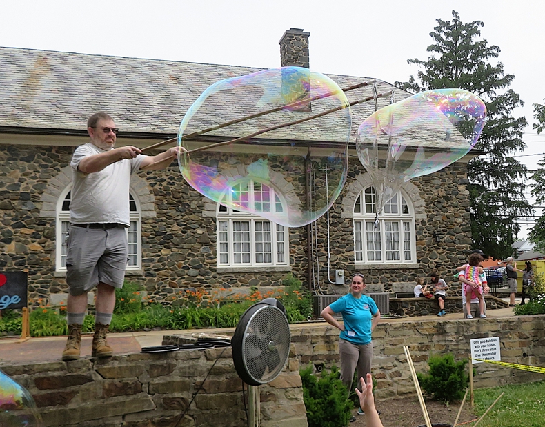 Kevin standing on the stone wall making big bubbles