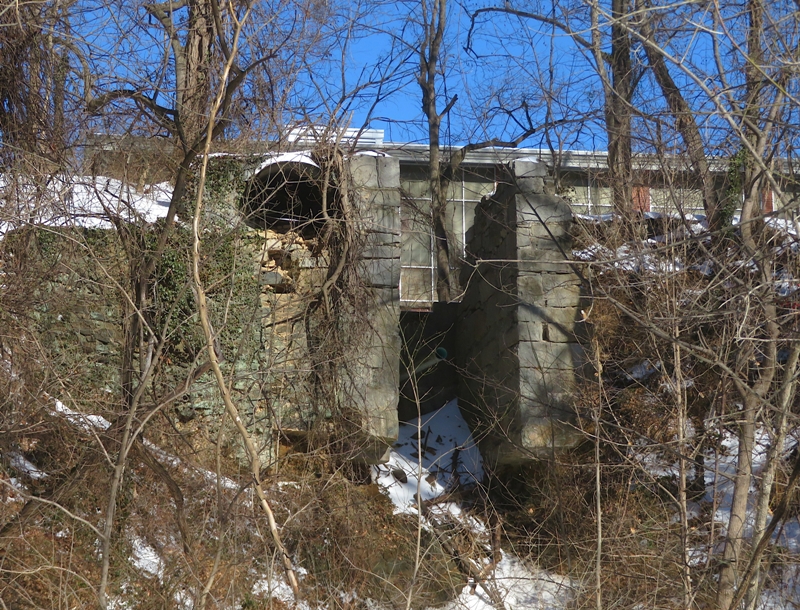 Open gap between two tall stone structures that likely held the waterwheel